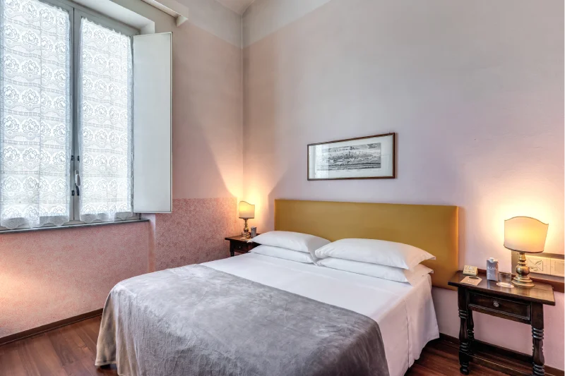 Bright double room with large bed, mustard headboard, pink walls and vintage bedside tables - Hotel Rex, BZAR hotels in Lucca