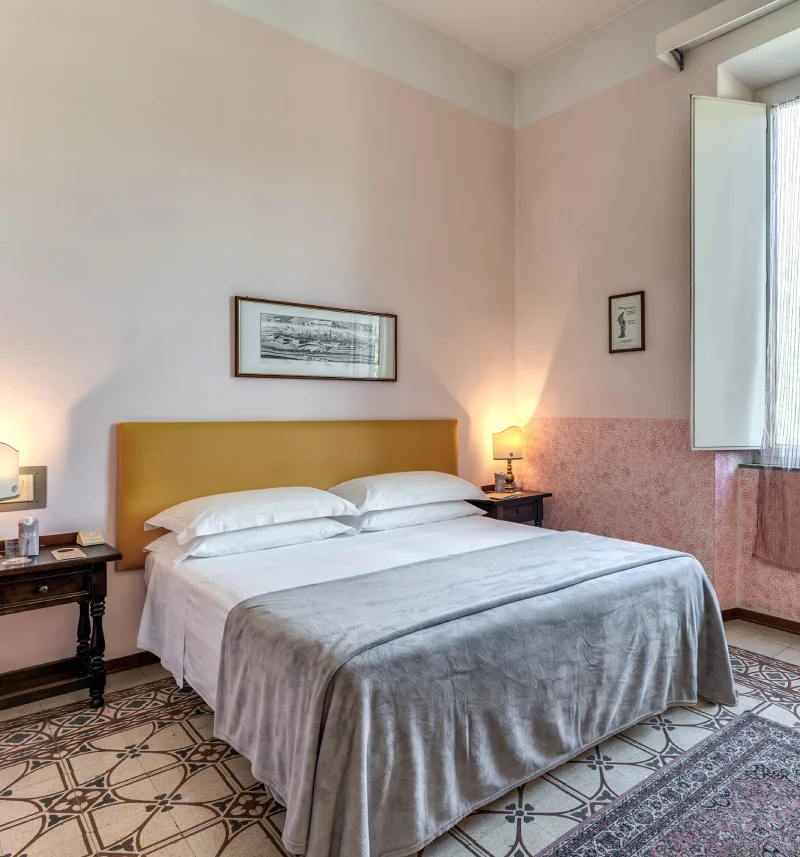 Classic double room with mustard headboard, decorated floor, vintage bedside tables and large window - Hotel Rex, BZAR hotels in Lucca